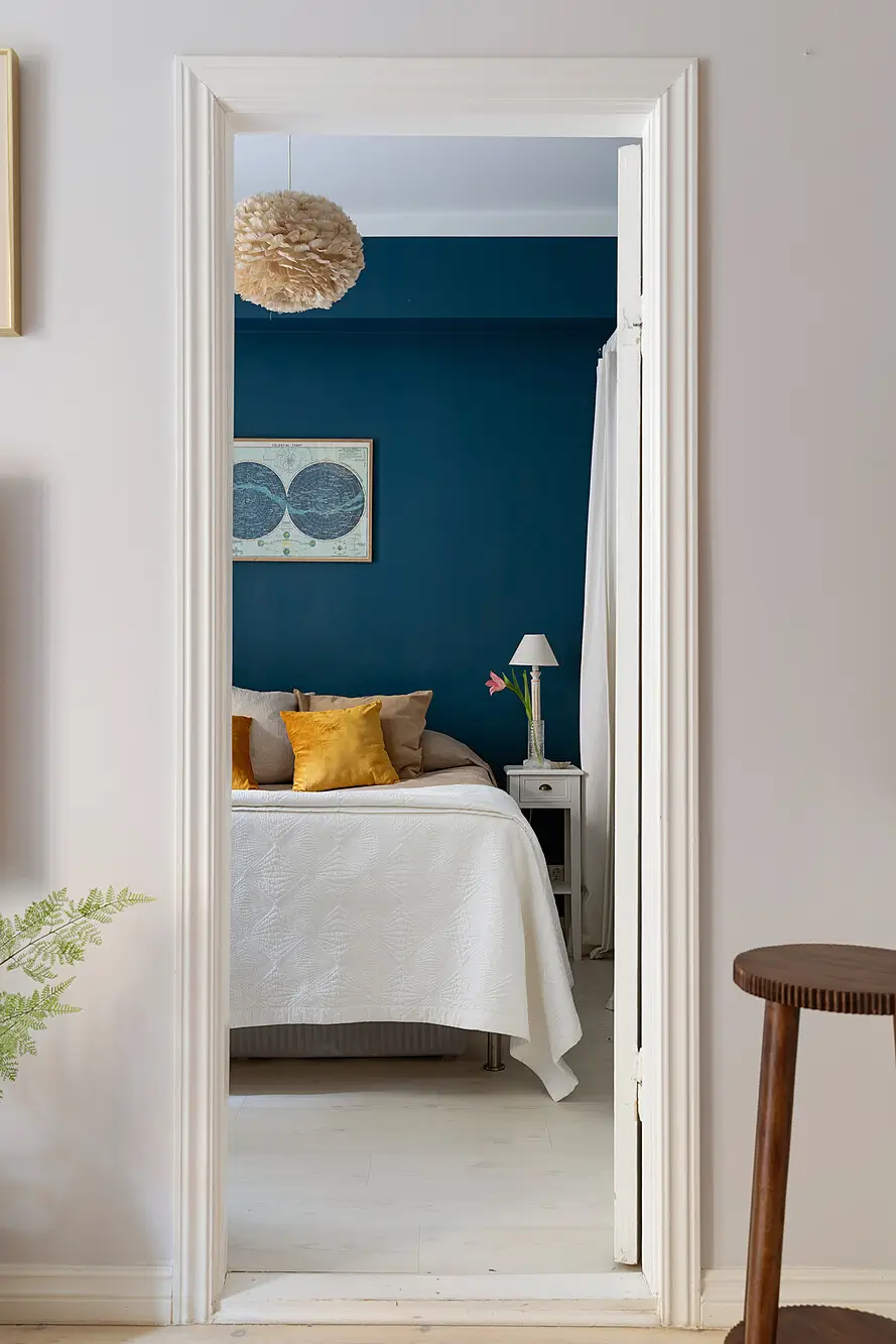 Red and Blue Color Accents in an Open-Plan Stockholm Apartment 13 view into dark blue bedroom