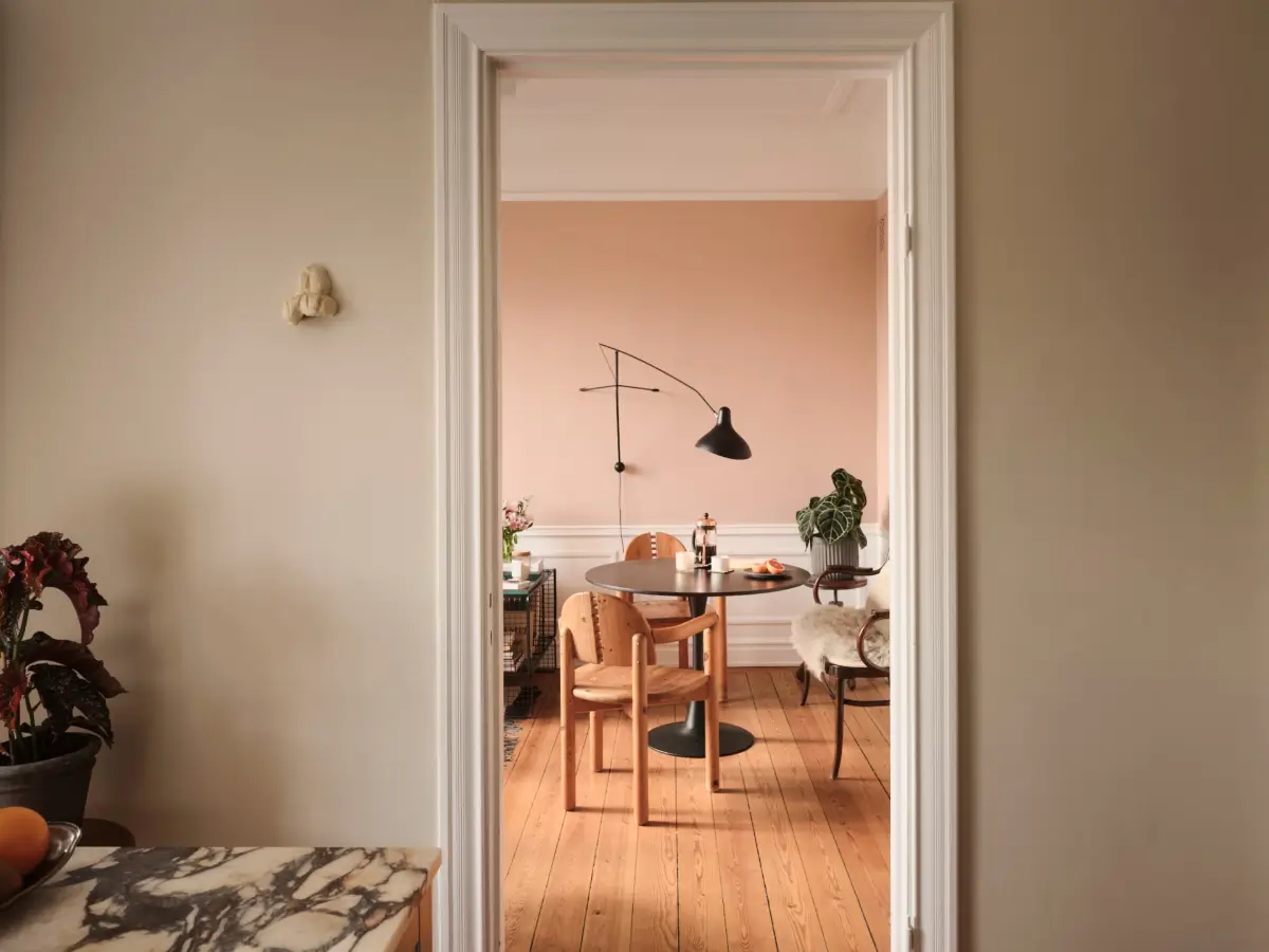 Warm Pink Walls and a Glass Room Divider in a Small Stockholm Apartment 25 view into living room