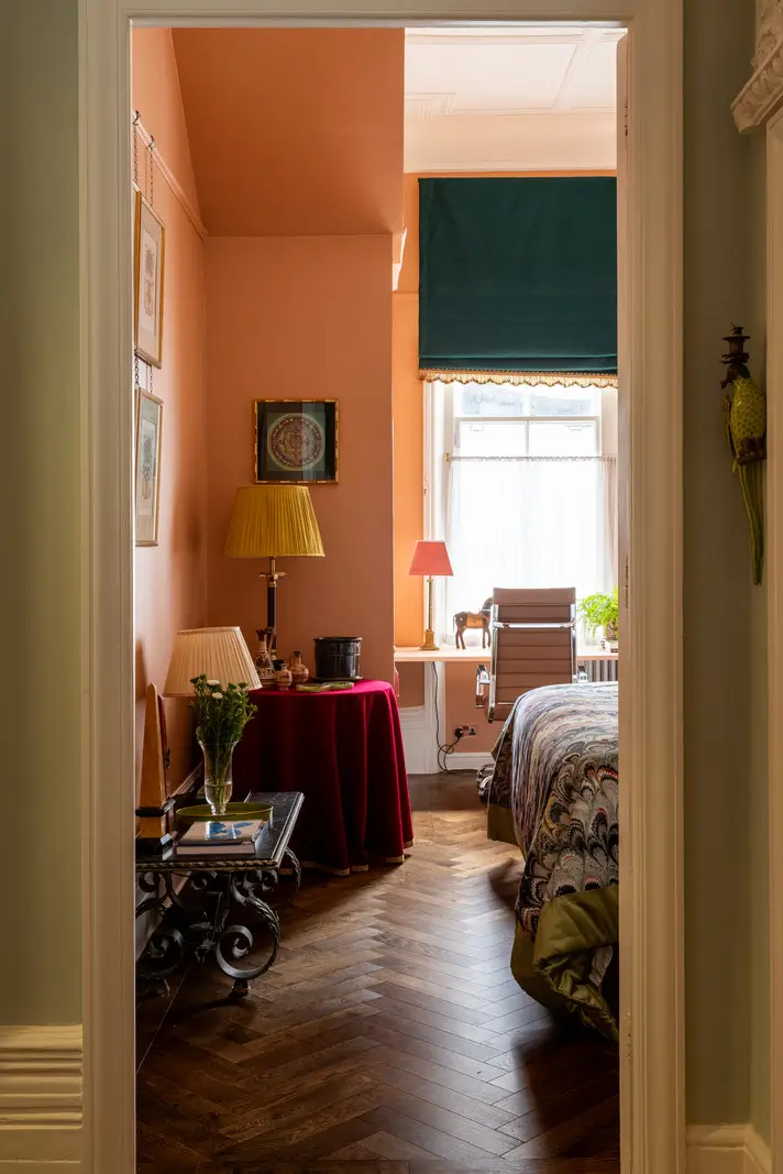 A Mixture of Patterns, Colors, and Materials in a Stunning London Apartment 14 view into orange bedroom with home office