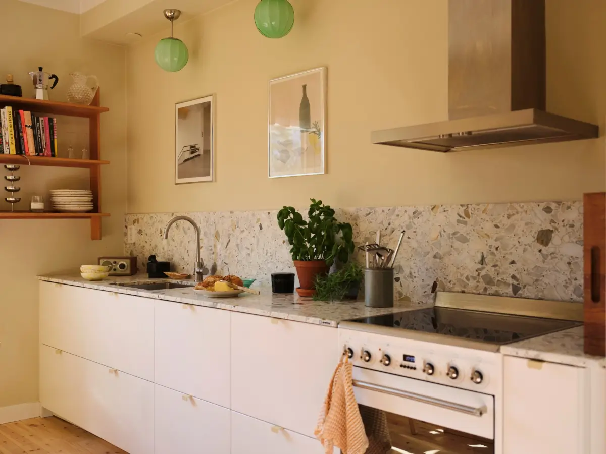 Soft Beige Interiors with the Occasional Bright Color Pop in Stockholm 12 white kitchen terrazzo countertop backsplash
