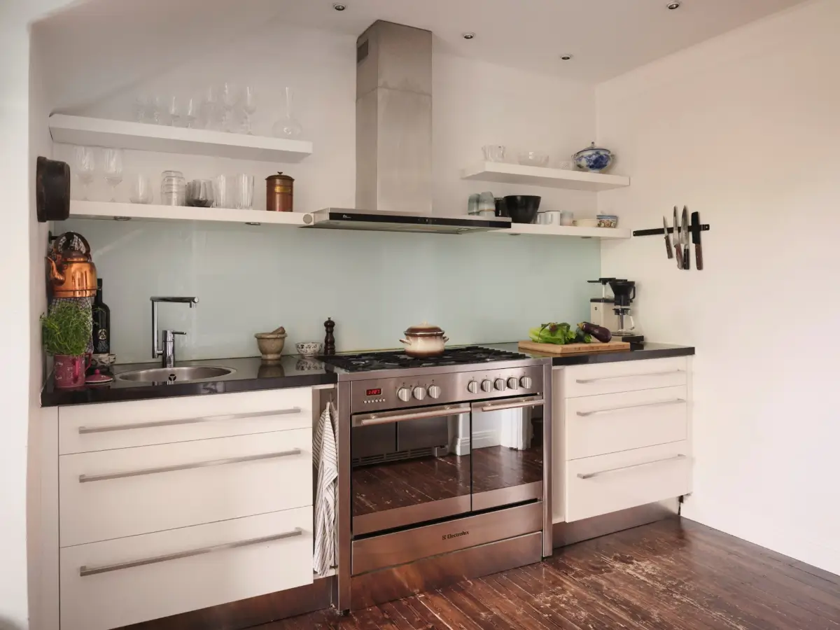 Exposed Beams and Dark-Stained Floorboards in a Cozy Attic Apartment 14 white kitchen