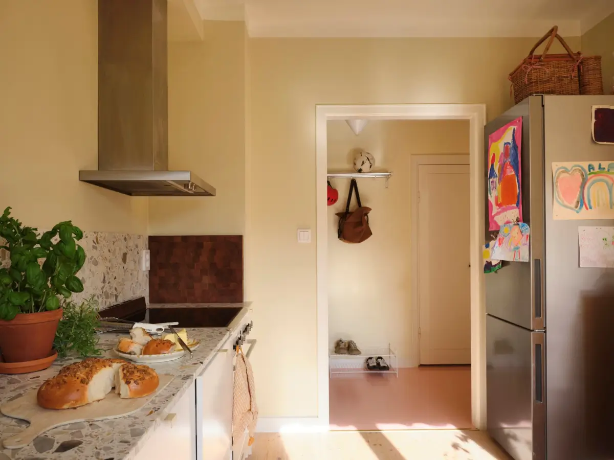 Soft Beige Interiors with the Occasional Bright Color Pop in Stockholm 18 white ktichen cabinets beige-yellow walls