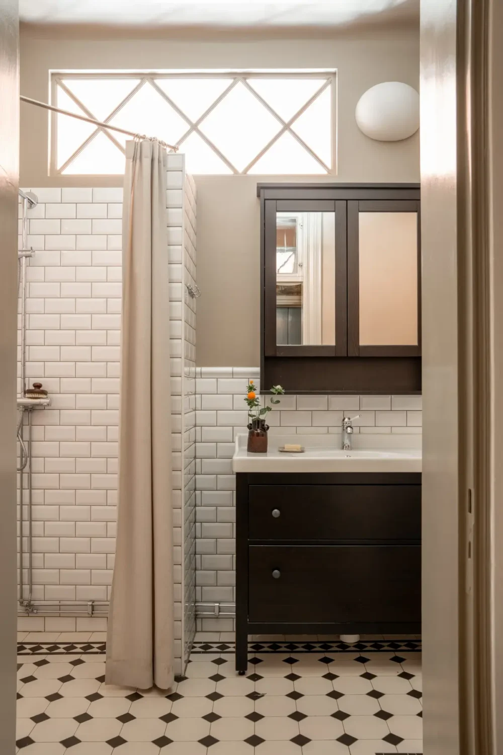 Historic Elegance and a French-Style Kitchen and Bathroom in a Stockholm Apartment 37 white tiled bathroom black vanity cabinet