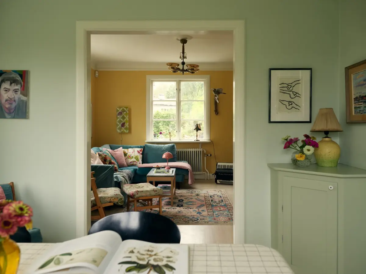 A Cheerful Color Palette in an Early 20th Century Villa in Stockholm 5 wide doorway living room dining room