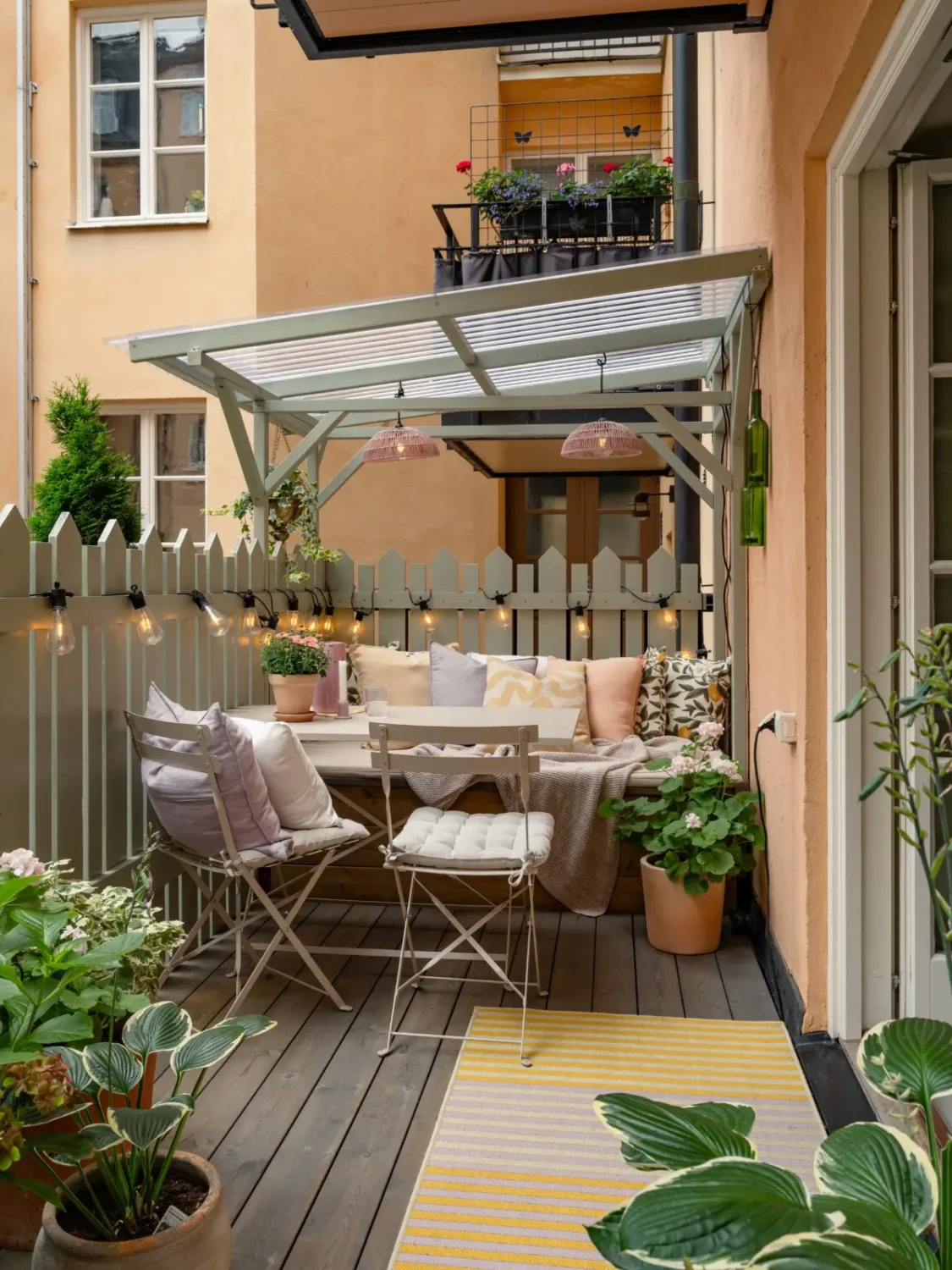 A Light Color Palette and a Charming Private Patio in a Stockholm Apartment 8 wooden terrace built-in bench