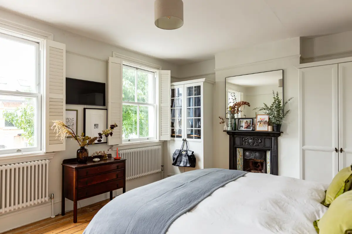 Period Elements and Subtle Color Accents in a Victorian Family Home 14 bedroom large windows with shutters black fireplace