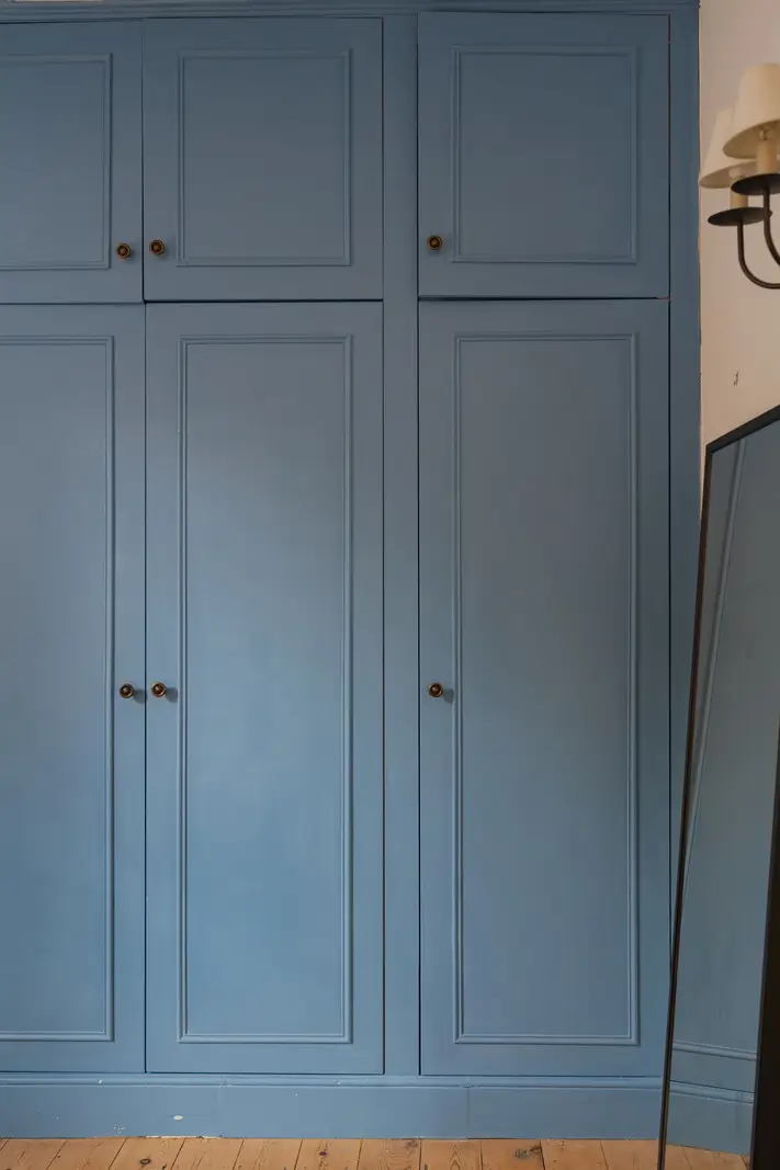 A Charming English Cottage with a Sage-Green Kitchen 18 blue built-in wardrobes