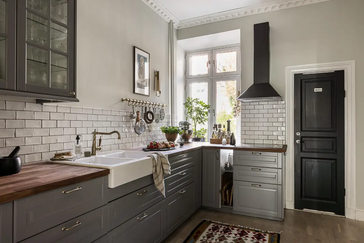 Warm Neutral Tones and Period Features in a Swedish Apartment 17 classic gray kitchen butler sink white backsplash tiles