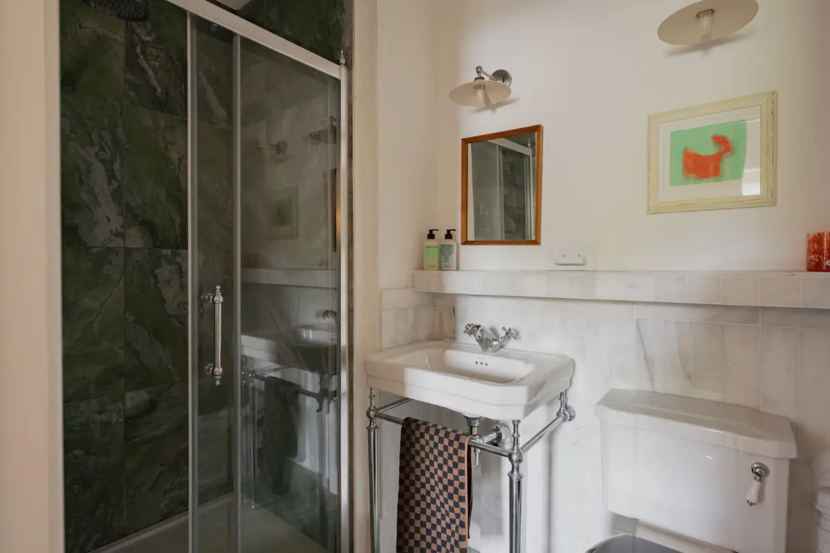 A Charming English Cottage with a Sage-Green Kitchen 15 cottage bathroom green shower tiles