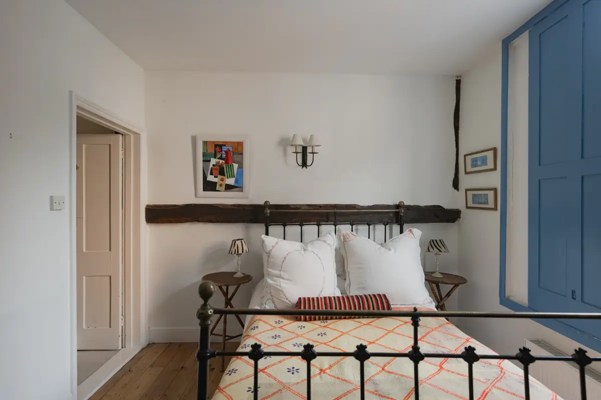 A Charming English Cottage with a Sage-Green Kitchen 16 cottage bedroom exposed beam blue shutters
