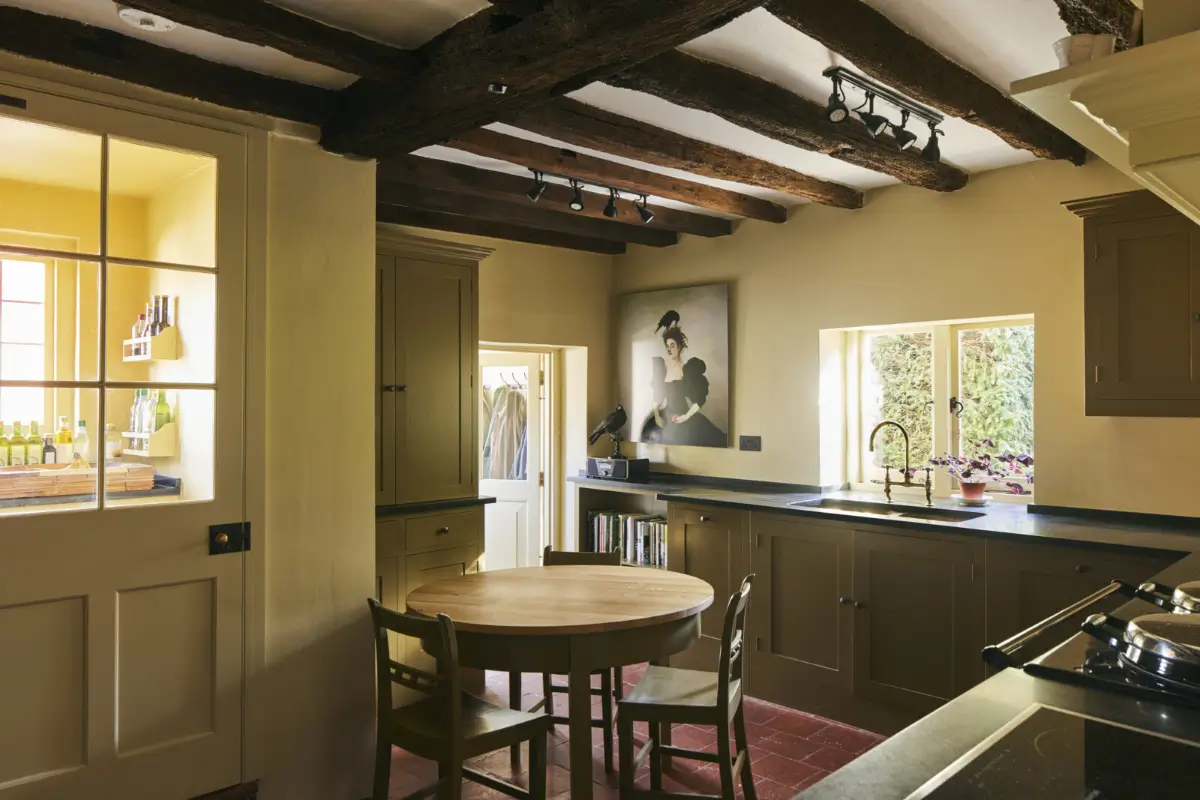 The Color Trends for 2026: A Return to Nature, Balance, and Grounding 27 green-kitchen-cabinets-wooden-beams-stone-floor-nordroom