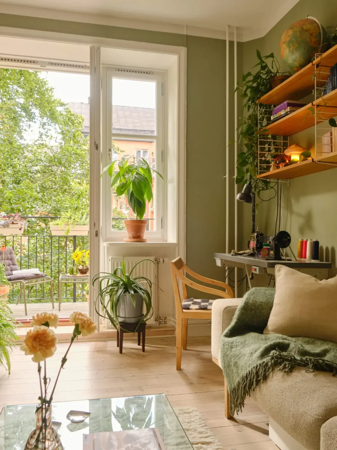 Green and Apricot Rooms in a Charming Stockholm Apartment 5 green living room desk wooden shelves