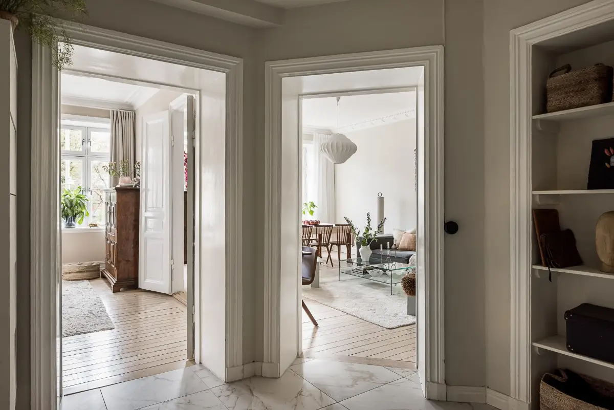 Warm Neutral Tones and Period Features in a Swedish Apartment 26 hall built-in shelves
