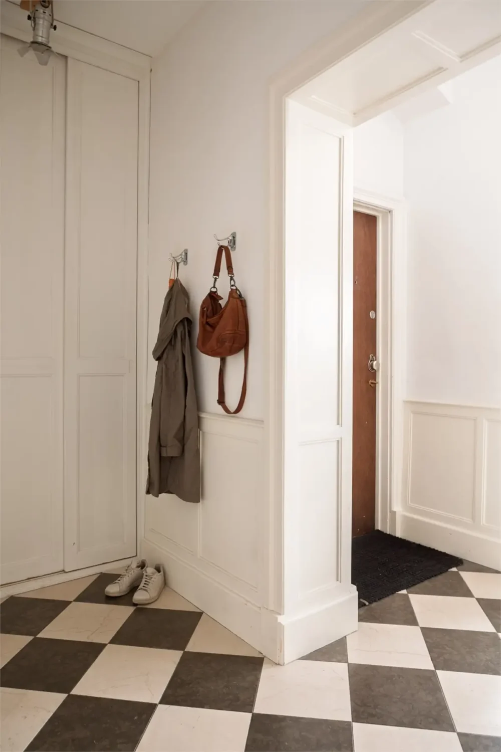 A Light-Filled Stockholm Apartment with a Charming Kitchen 33 hall checkerboard floor 1 A Light-Filled Stockholm Apartment with a Charming Kitchen