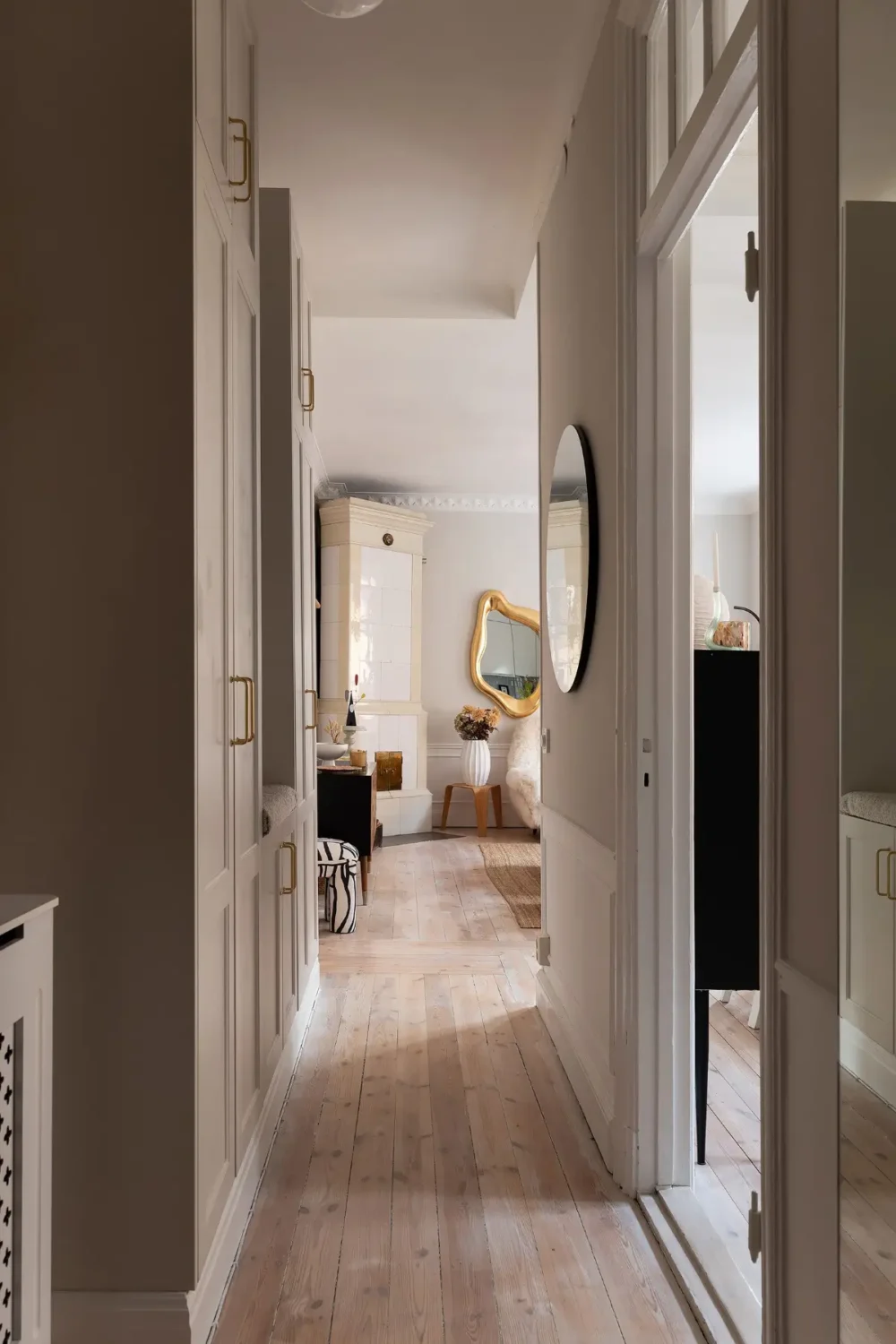 Neutral Tones and Period Character from the 1910s in a Stockholm Apartment 25 hall wooden floor built-in wardrobes