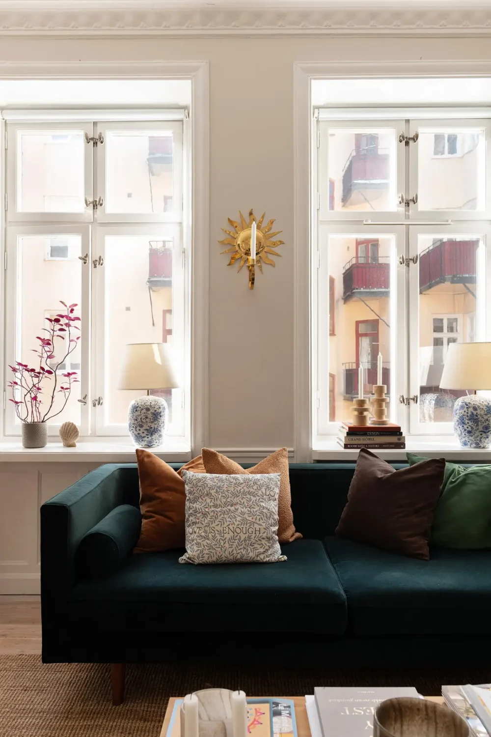 Neutral Tones and Period Character from the 1910s in a Stockholm Apartment 3 living room large windows velvet green sofa
