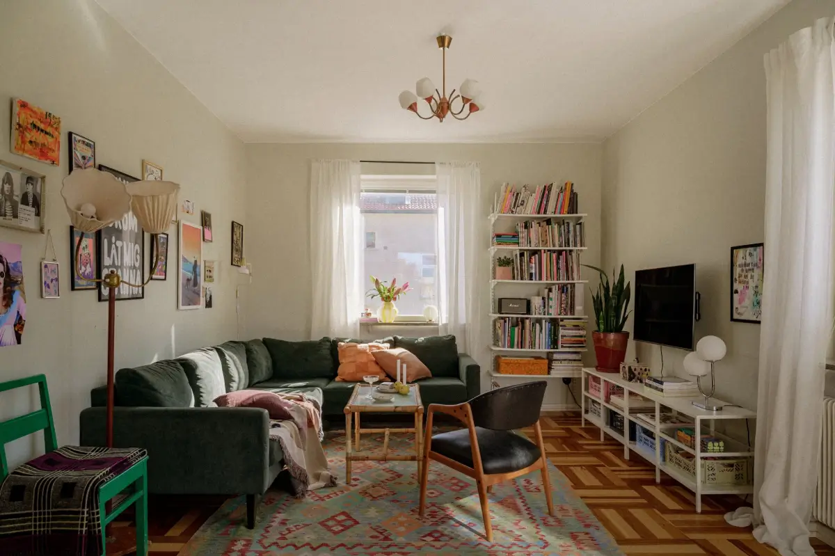 Green Tones and Period Elements in a 1940s Apartment 1 living room parquet floor green sofa colorful rug