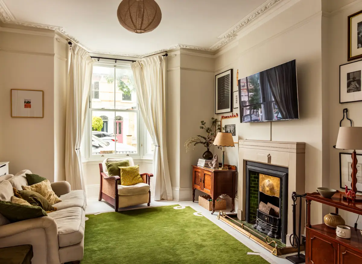 Period Elements and Subtle Color Accents in a Victorian Family Home 2 living room period detailing green rug fireplace