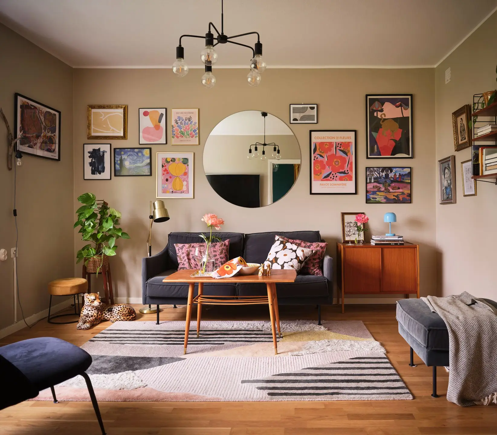 living room with round mirror and gallery wall