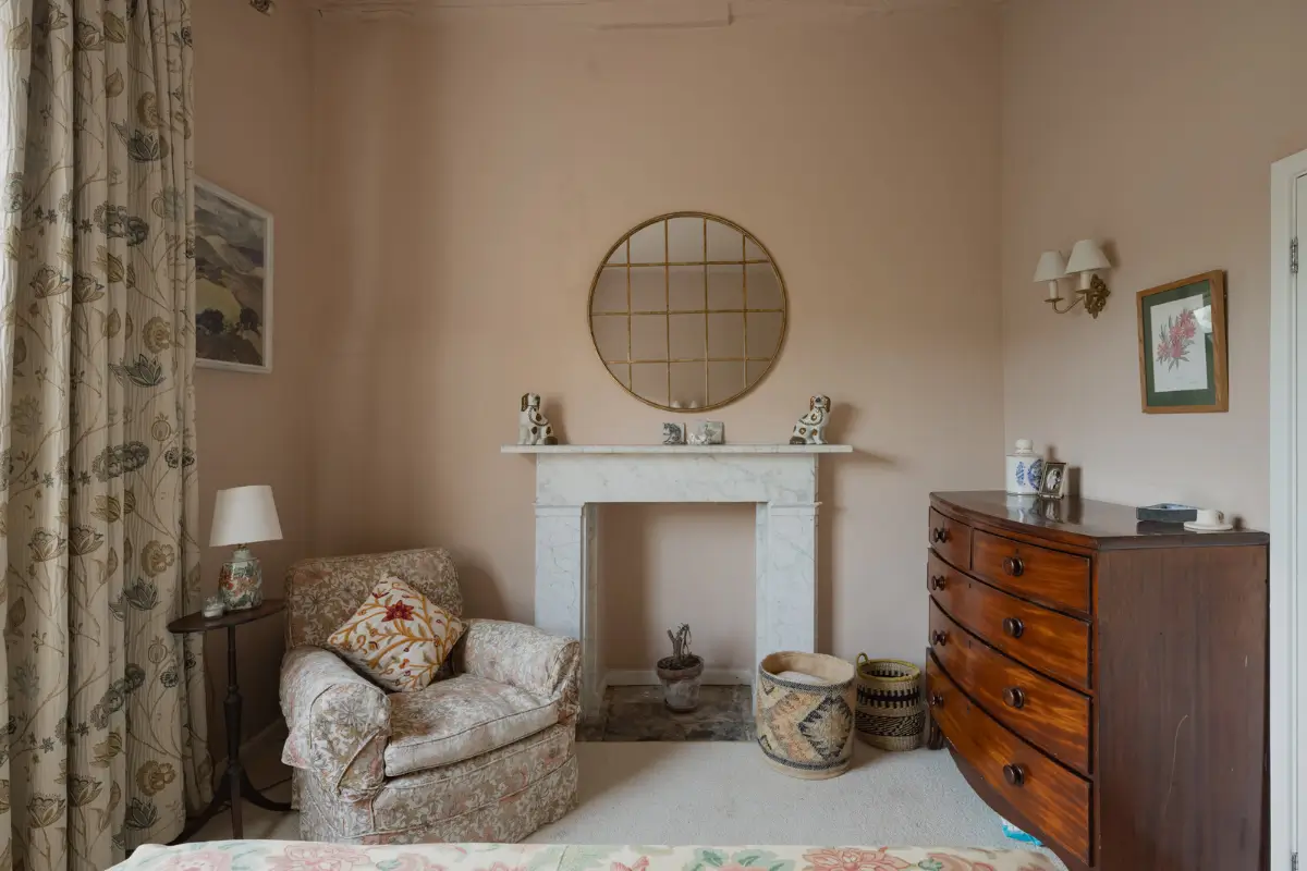 A Charming English Cottage with a Sage-Green Kitchen 12 pink cottage bedroom marble fireplace surround