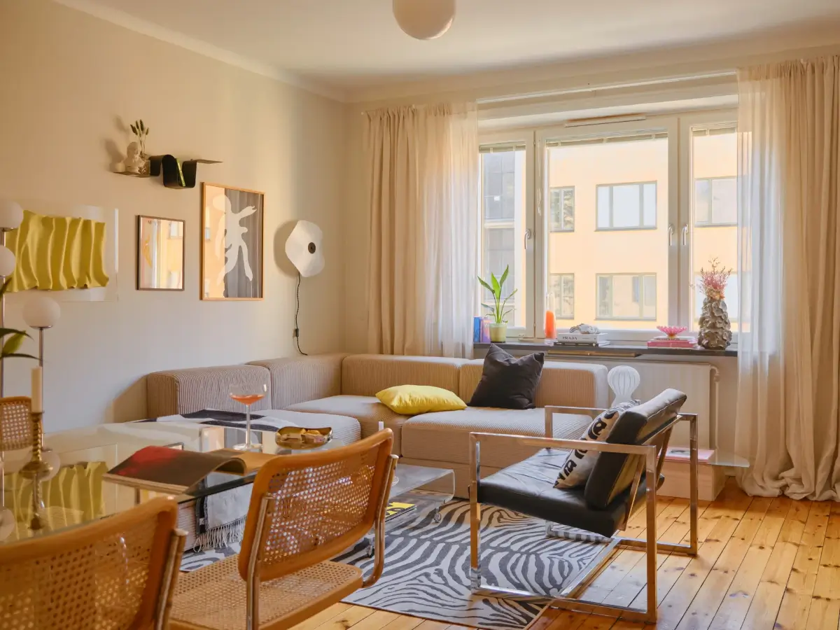A Light 1930s Apartment with a Bubblegum Pink Bedroom 1 scandi living room beige walls wooden floor zebra rug glass dining table