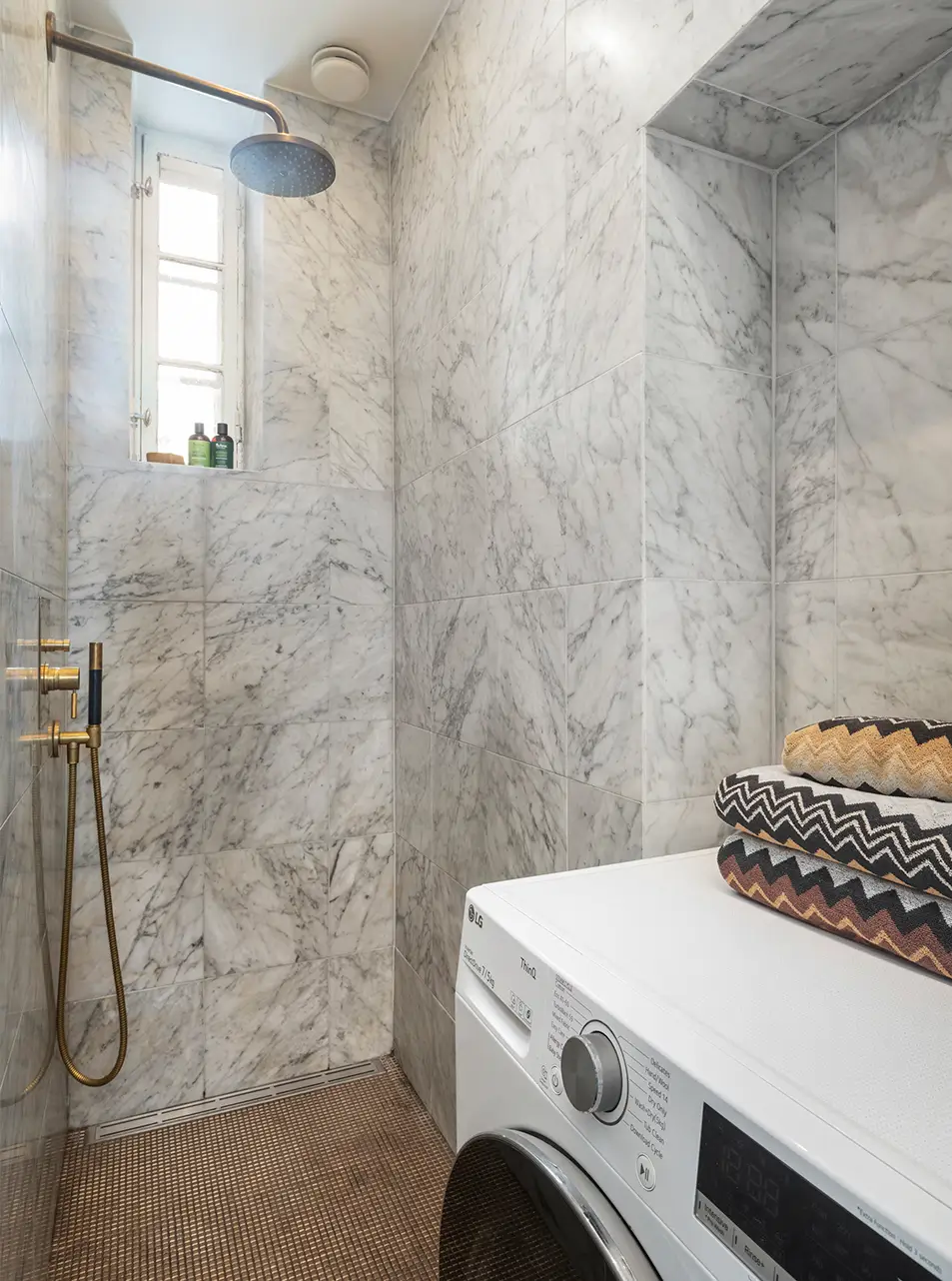 small marble bathroom with washing machine
