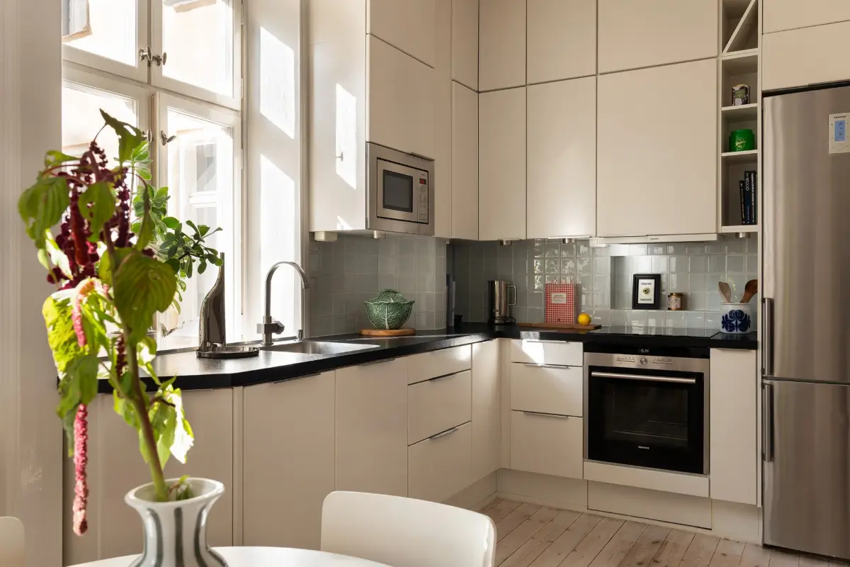 Neutral Tones and Period Character from the 1910s in a Stockholm Apartment 14 white kitchen with blue-gray backsplash tiles