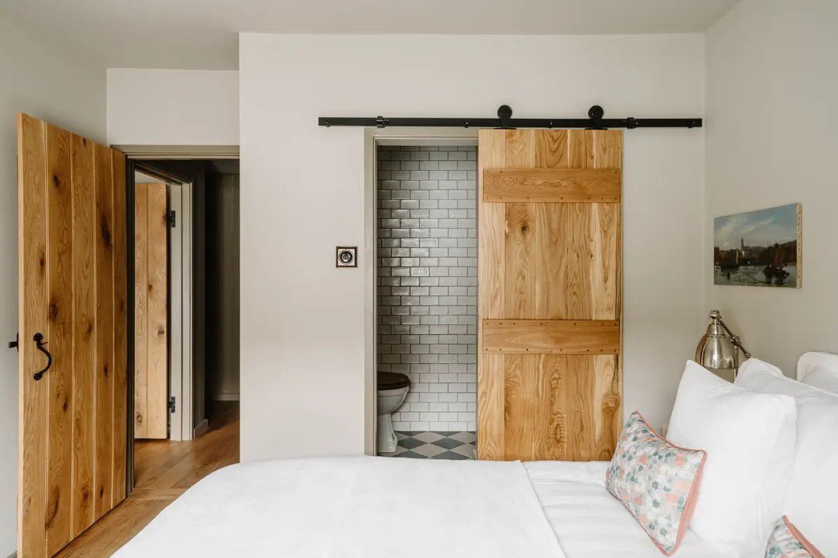 Natural Materials and Green Tones in a Pretty Coastal Home 13 barn door en-suite bathroom