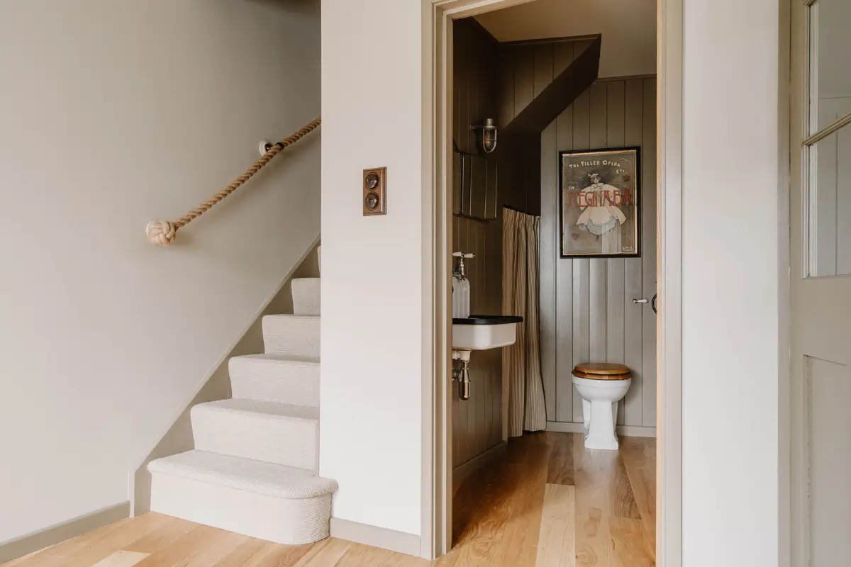 Natural Materials and Green Tones in a Pretty Coastal Home 8 guest toilet staircase