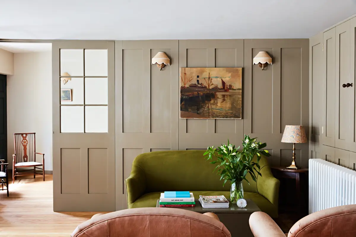 Natural Materials and Green Tones in a Pretty Coastal Home 6 living room paneling green sofa