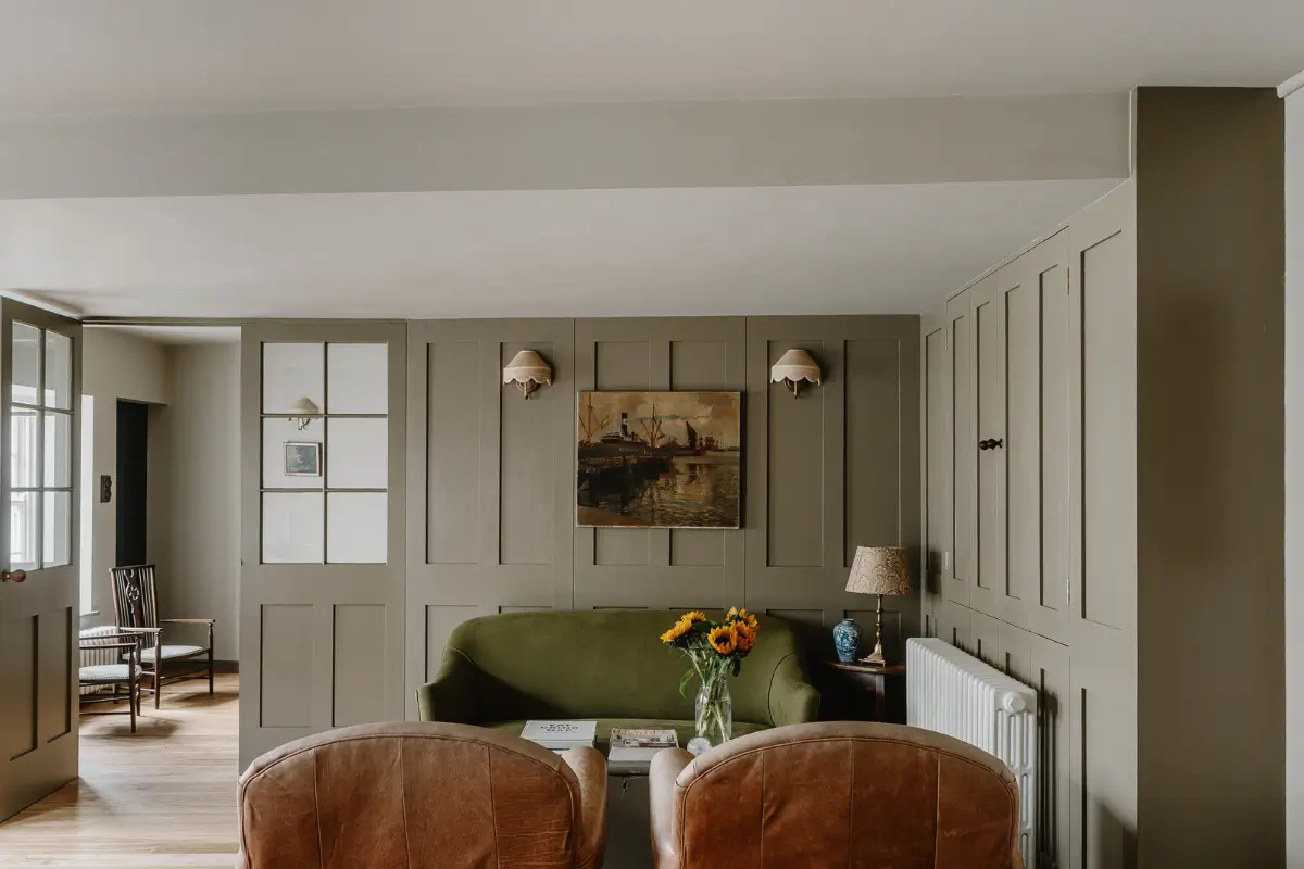 Natural Materials and Green Tones in a Pretty Coastal Home 4 living room velvet green sofa wall paneling