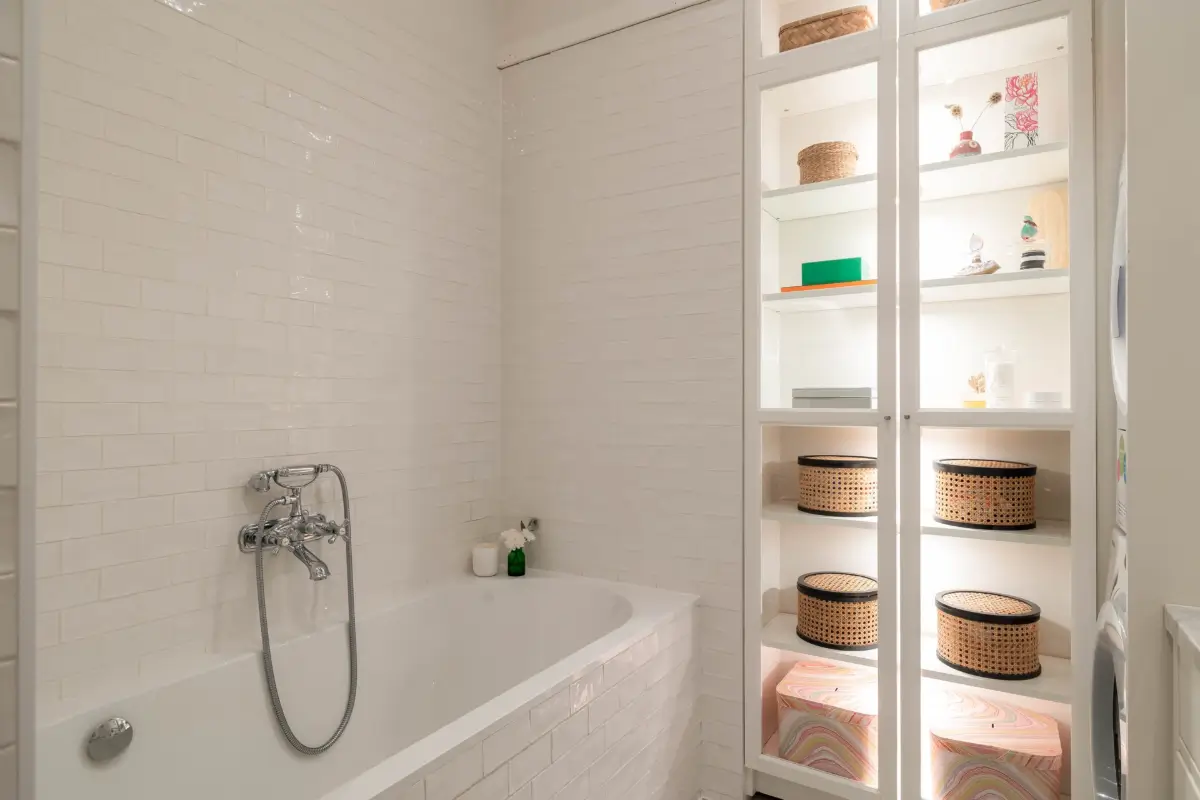 Classic Elements and Modern Comforts in an Elegant Apartment 11 white-tiled bathroom with bath and built-in lighted cabinet