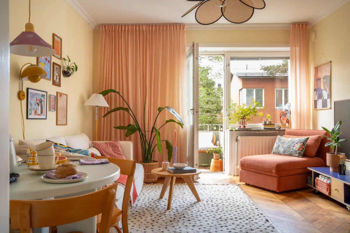 Cheerful Colors in a Small & Light 1940s Apartment in Stockholm 2 living room light yellow walls chevron floor pink curtains nordroom
