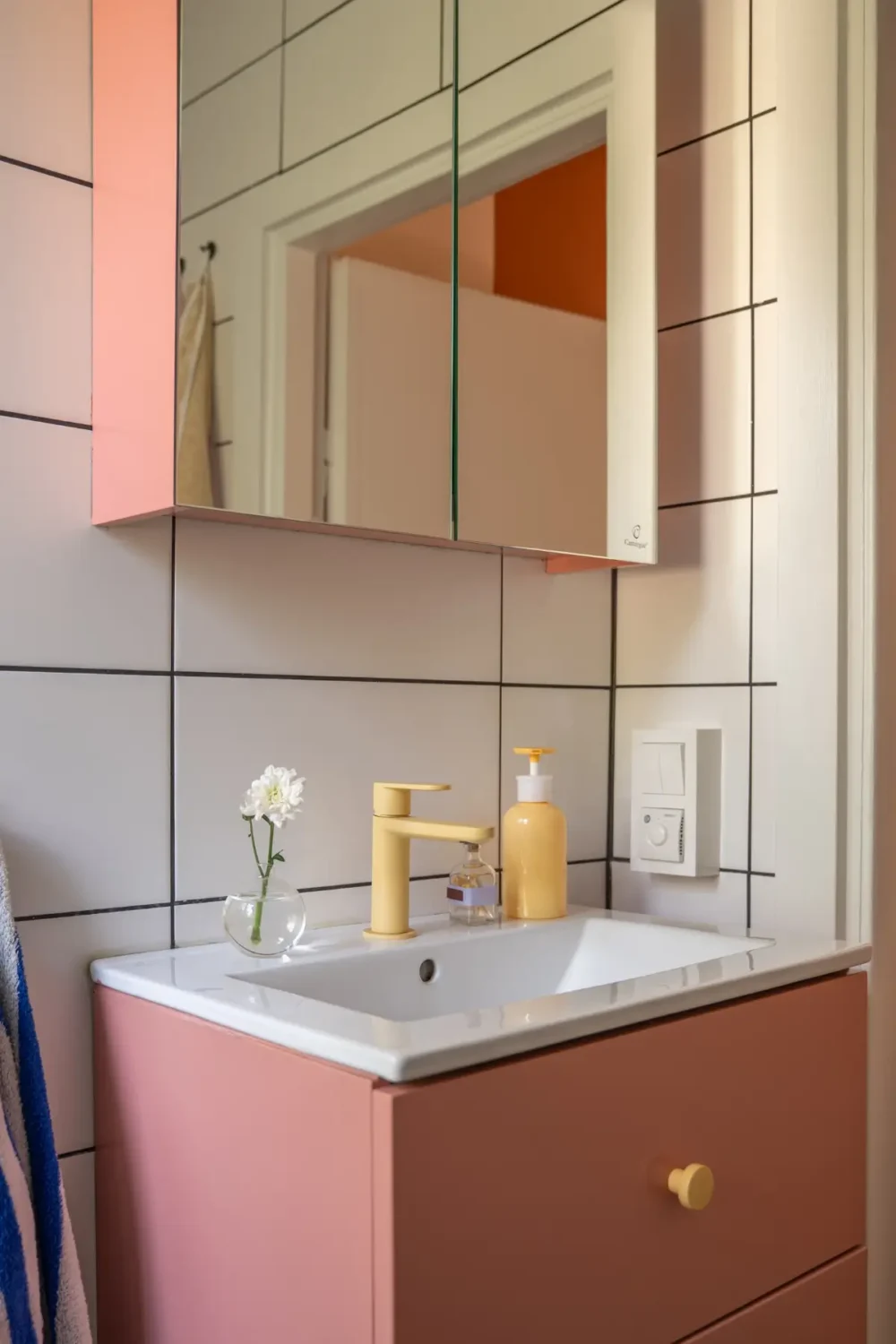 Cheerful Colors in a Small & Light 1940s Apartment in Stockholm 31 pink-bathroom-cabinets-yellow-faucet-nordroom