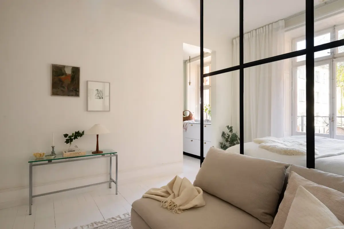 An Elegant Stockholm Apartment Blends Modern Elements with Period Features 25 bright-studio-apartment-industrial-glass-room-divider-lush-balcony