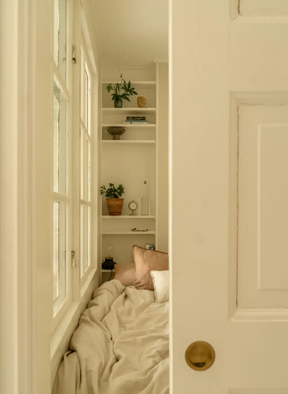 A Dividing Wall with Flea Market Windows Creates a Cozy Sleeping Niche in this Apartment 13 light-filled-turn-of-the-century-apartment-stockholm-nordroom