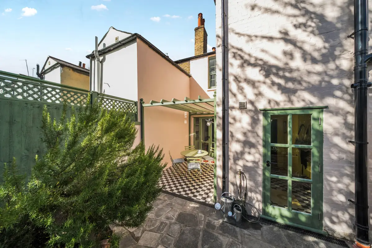 A London Family Home with a Pink deVOL Kitchen and Mint-Green Floorboards 17 garden-pink-exterior-walls-green-doors-checkered-patio